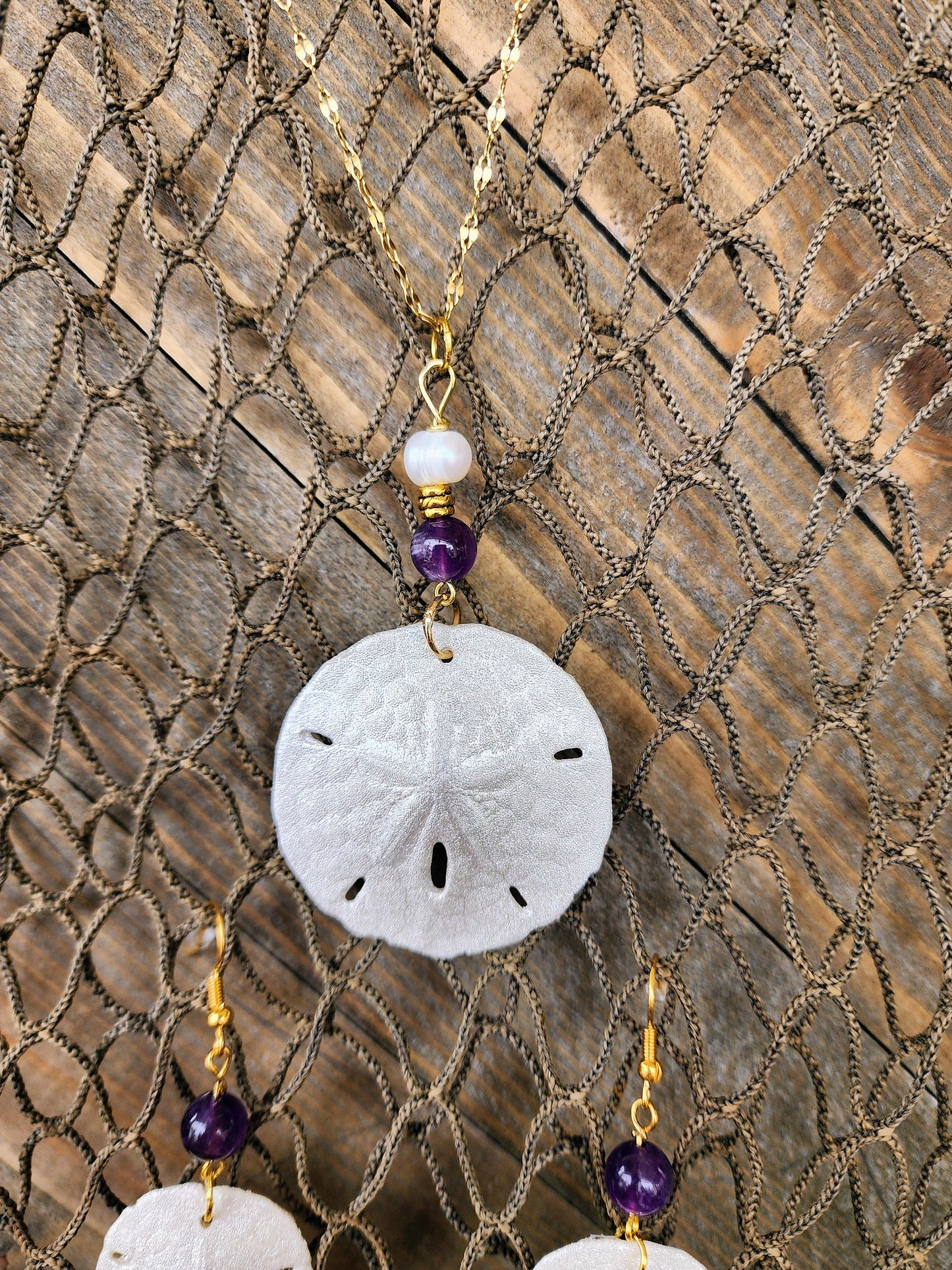 Real handmade sand dollar necklace and earring set accented with amethyst and fresh water pearl beads. Sand dollar pendant and earrings set