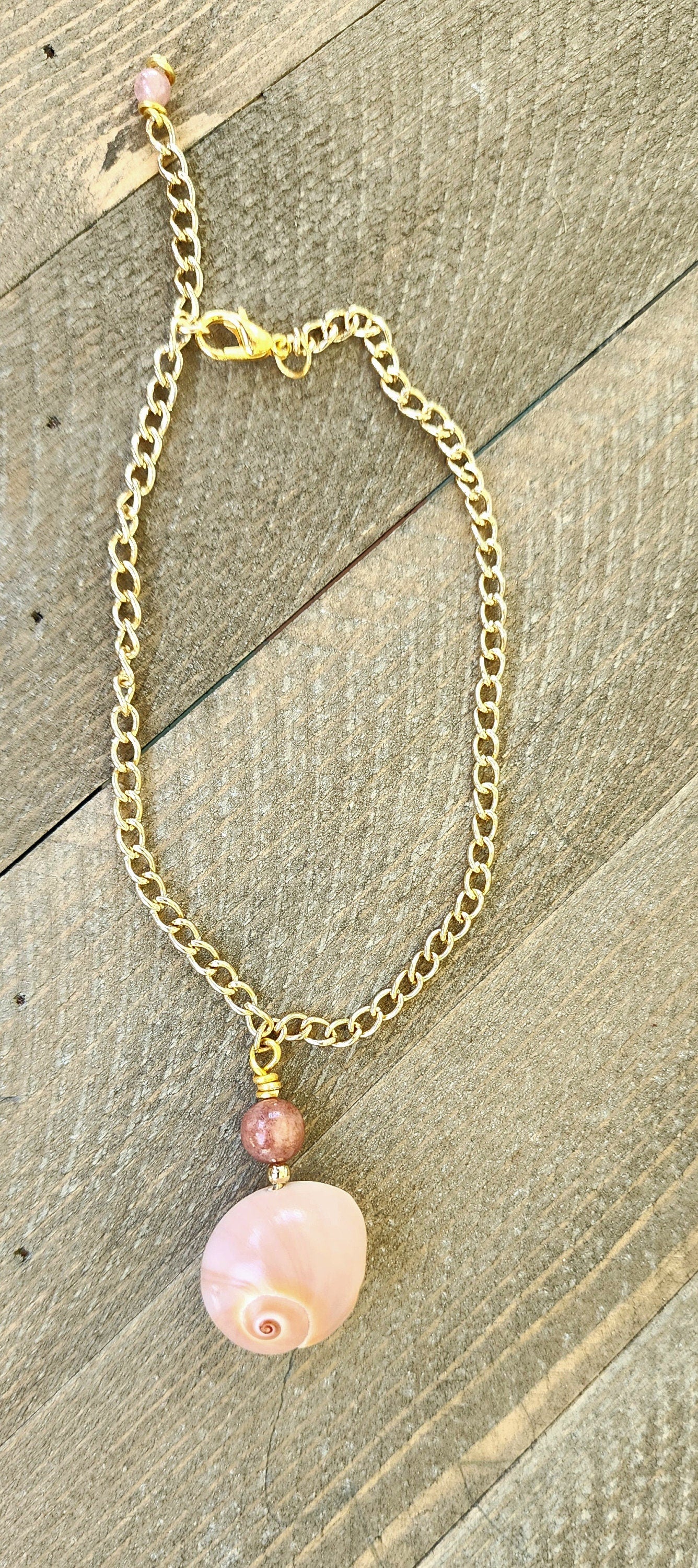 Genuine handmade shark eye moon snail bracelet or anklet accented with a semi- precious sun stone bead on a Gold curb style stainless chain.