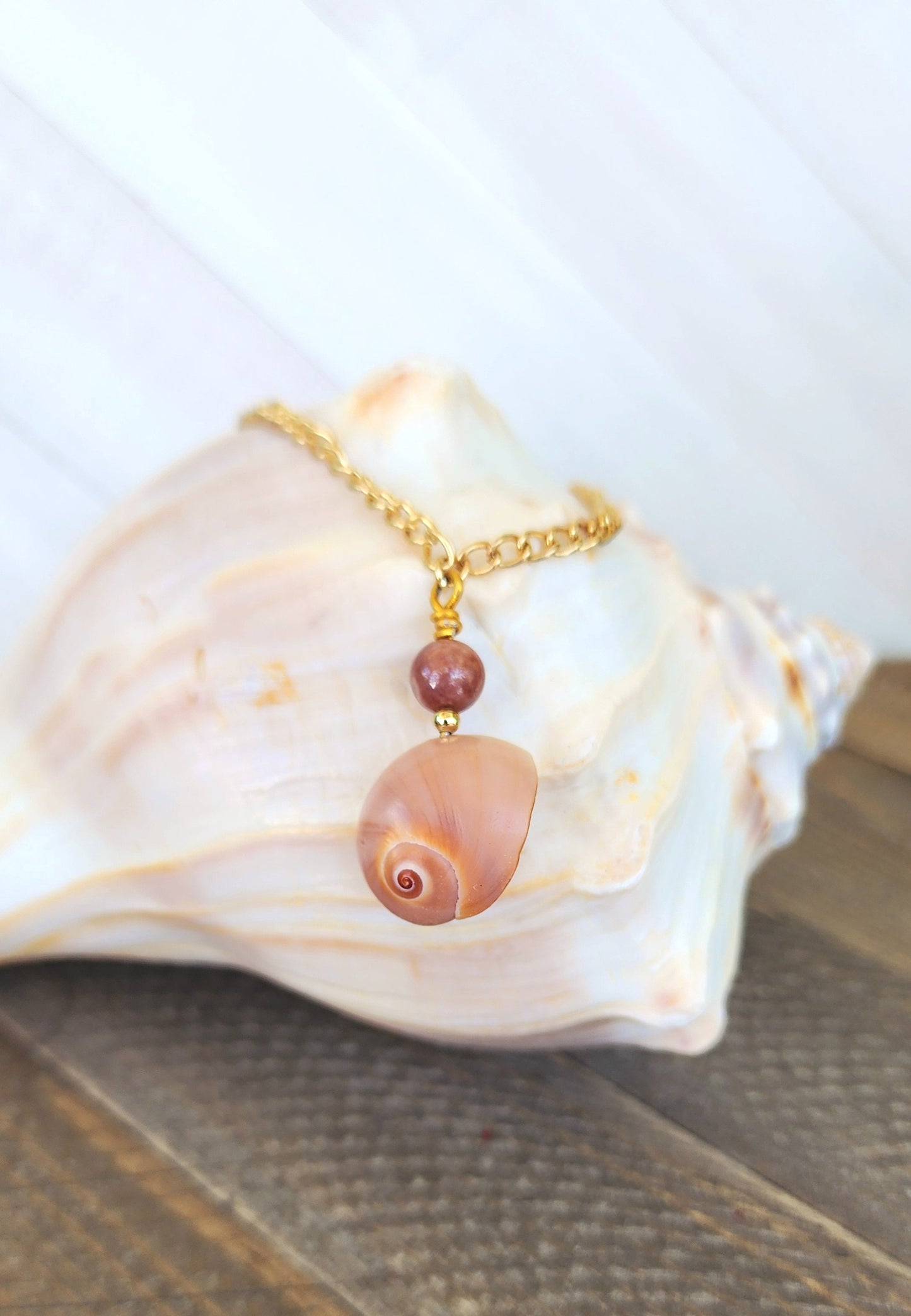 Genuine handmade shark eye moon snail bracelet or anklet accented with a semi- precious sun stone bead on a Gold curb style stainless chain.