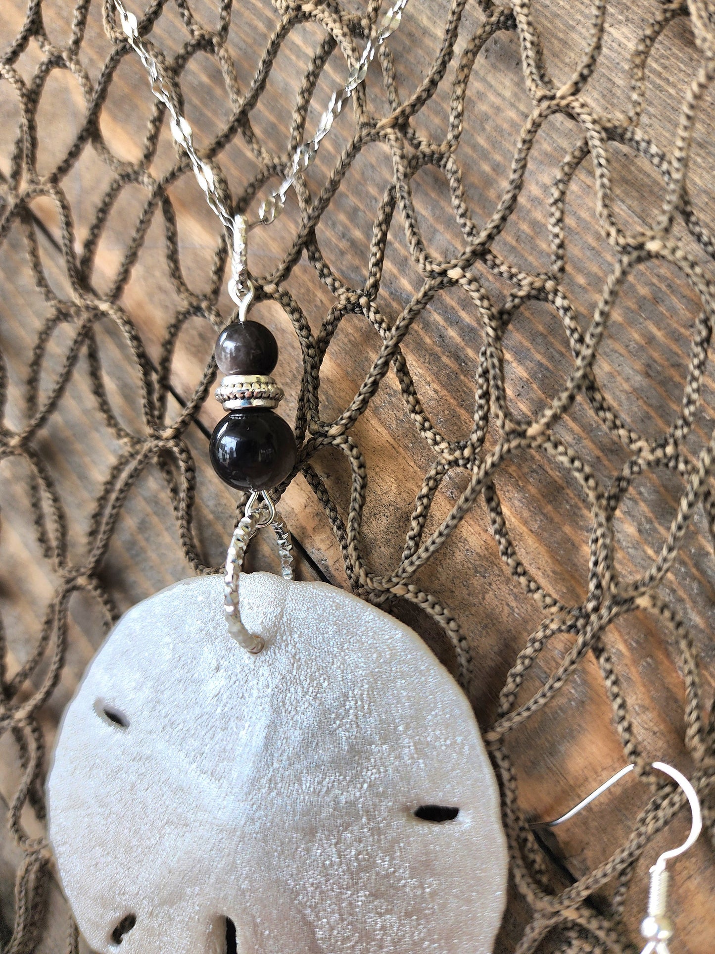 Stunning and elegant handmade sand dollar necklace and earrings set with silver obsidian bead accents. Sand dollar pendant and earrings set