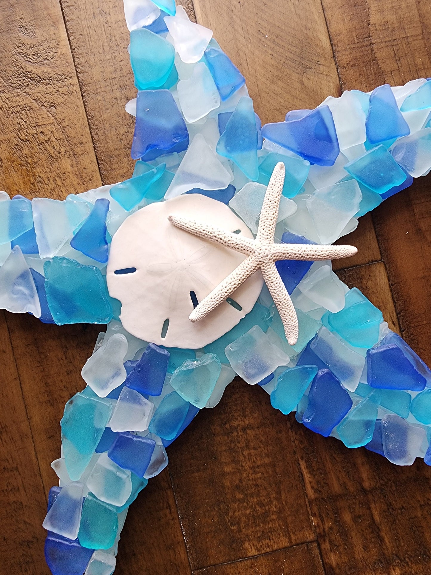 Sea glass starfish wall art hanging (12"x12") in blue, aqua, turquoise and white, finished with a sand dollar and starfish.