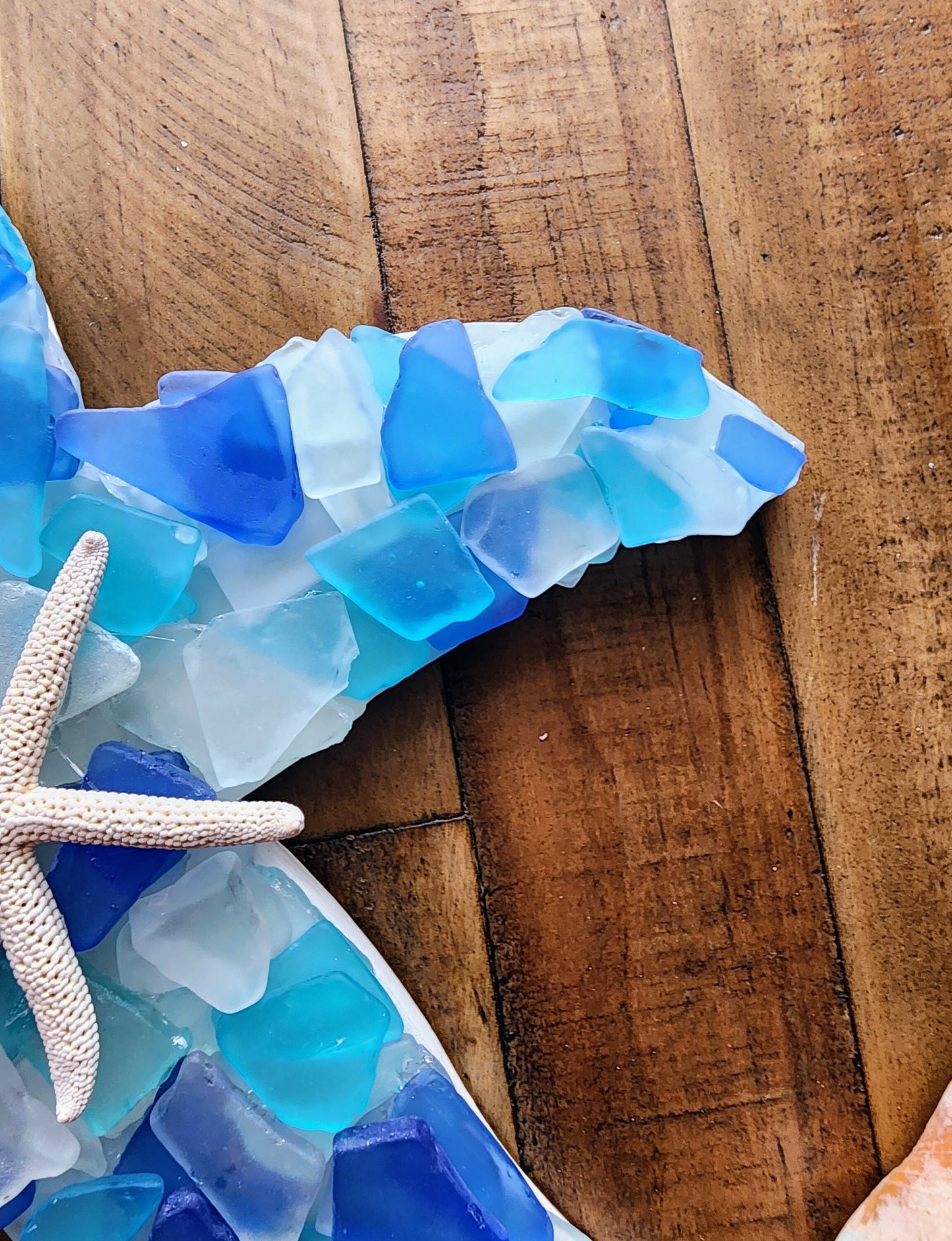 Sea glass starfish wall art hanging (12"x12") in blue, aqua, turquoise and white, finished with a sand dollar and starfish.