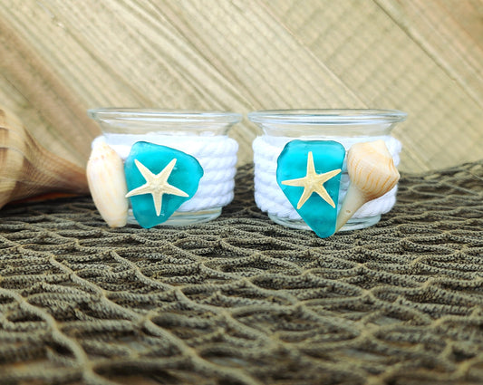 Set of 2 coastal candle holders for tealight or votive candles, wrapped in white rope with turquoise seaglass, and seashell accents.